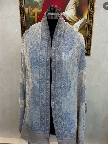A light-coloured pashmina with a subtle blue and grey paisley design. This is a very versatile scarf that can be worn year-round.