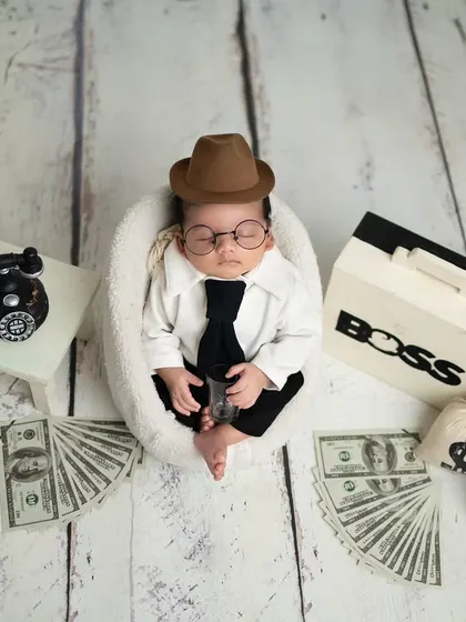 Let's have some fun. My 'Boss Baby' theme is always a hit with parents. Complete with a tiny suit, tie, and fun props like a briefcase and money bags, it’s a playful way to capture your little one's big personality.