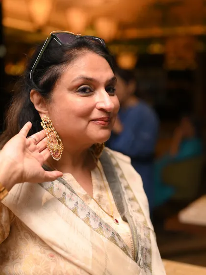 A guest tries on a pair of magnificent chandelier earrings during our exclusive showcase, finding the perfect statement piece for an evening look.