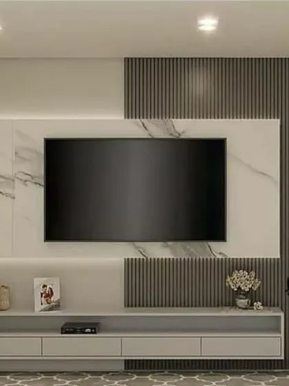 This media wall combines a white marble-look panel with dark grey fluted sections for a high-contrast, modern aesthetic. The floating console offers ample storage while maintaining a light and airy feel.
