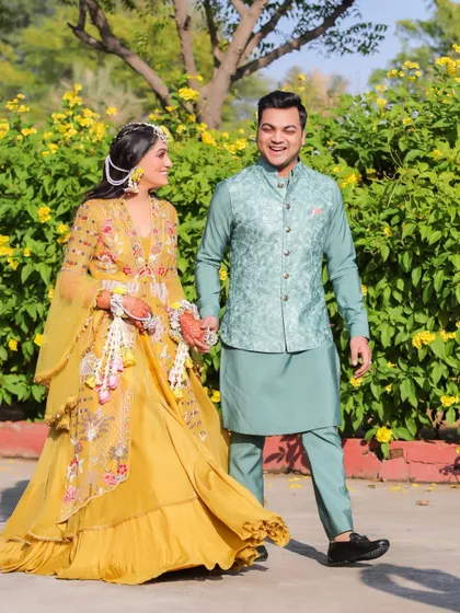 The couple takes a stroll, hand in hand, during their outdoor Haldi event. We capture these natural, in-between moments that tell the story of your day.