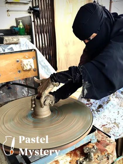 A participant, fully engaged, works on the pottery wheel. This image captures the quiet focus and artistry that happens during our sessions.