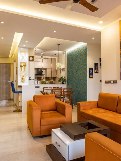 This Mumbai home is a curated expression of warmth and personality, featuring a vibrant living room with a bold orange sofa and a striking piece of abstract art.