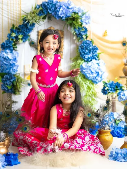 Two sisters sharing a happy moment during their Radha-themed photoshoot. Capturing the joy and laughter between siblings is always a priority.