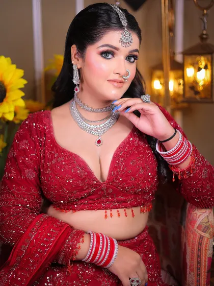 A confident portrait that showcases the intricate details of the blouse and jewelry.