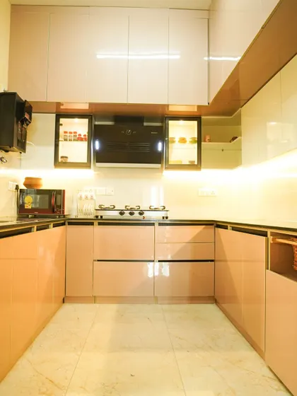 A wide shot of the pink and white kitchen, demonstrating how the U-shaped layout creates a contained and efficient workspace. The design is perfect for those who love a bright and organized kitchen.