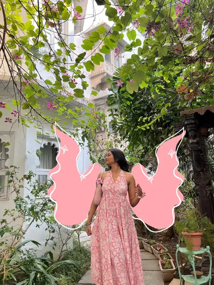 A pretty photo in a garden, with pink angel wings doodled on.