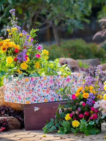 The floral trunks add a vintage and whimsical touch to the garden decor of the Haldi ceremony.