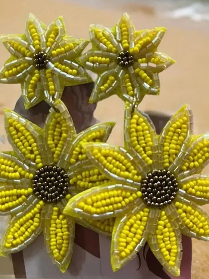 Our yellow tiered floral earrings enjoying a day at the beach. The vibrant yellow beads sparkle in the sun, making these the perfect accessory for your next seaside getaway.