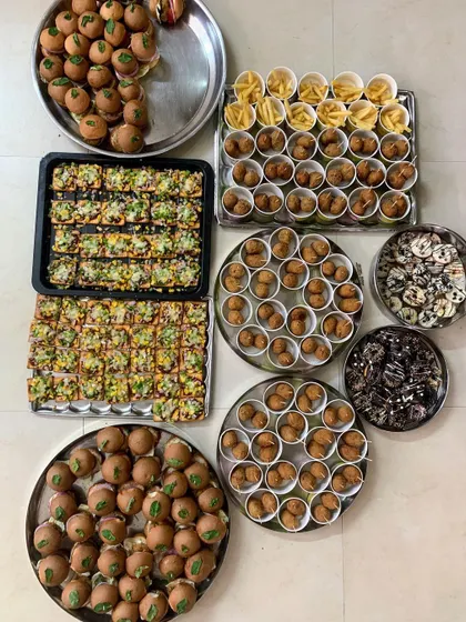 All the components for a fun party spread out and ready for packing. This includes mini burgers, pizza crackers, corn balls, fries, and doughnuts.