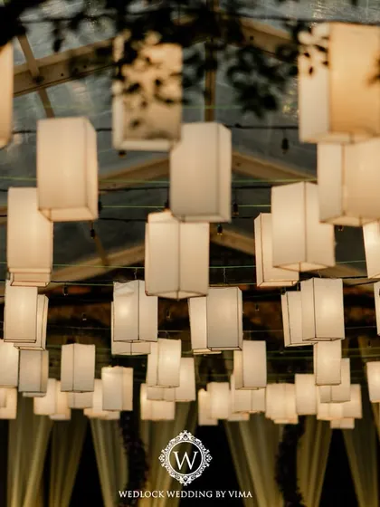 A simple yet elegant reception setup with soft lantern lighting and delicate drapes on the gazebo. The lush purple-themed florals and romantic centerpieces tied the whole look together.