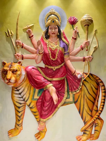 The final painted Maa Durga mural, illuminated to show the golden details and the fierce yet compassionate expression of the goddess and her tiger.