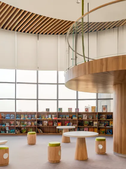 Another view of the Vedanya School library, showing the mezzanine level and child-friendly furniture. The design provides different vantage points and seating options to accommodate various activities and preferences.