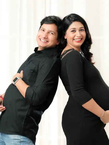 Another fun back-to-back pose, this time with the dad-to-be playfully showing off his "bump" too. These moments create lasting, joyful memories.