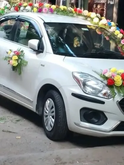 We also offer wedding car decorations using high-quality artificial flowers. This Maruti Dzire is decorated with vibrant, multi-colored floral bouquets for a bright and festive look suitable for the baraat.
