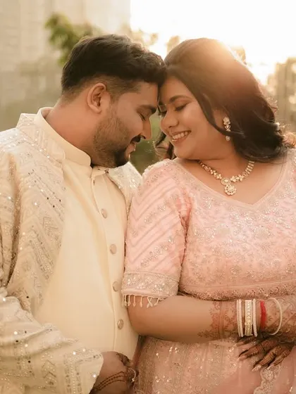 An intimate, sun-kissed portrait of the couple, their foreheads touching in a moment of quiet connection.