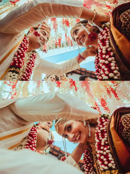 A low-angle shot capturing the joy and playfulness of the Varmala exchange.
