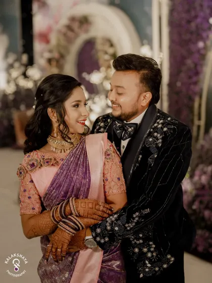 A happy and loving portrait of the couple at their reception, surrounded by beautiful decor.