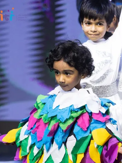A close-up of a child in a vibrant bird costume, his expression full of focus and character.
