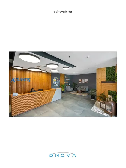 A wide view of the Atlantis office reception in Noida. My role as general contractor covered the complete execution of this space, including the custom reception desk, wood paneling, and circular ceiling lights.
