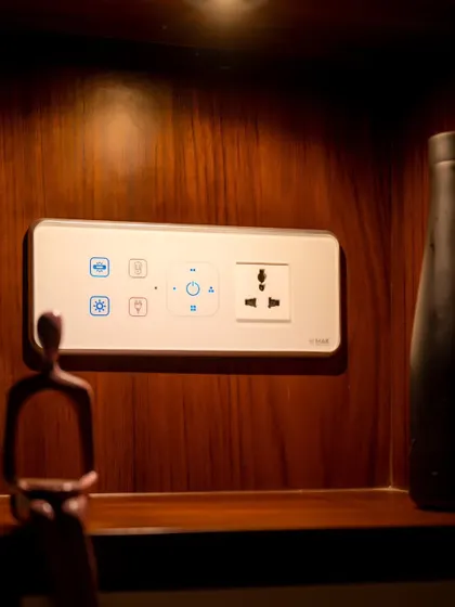 A white smart panel set against a dark wood background, providing a clear and modern point of control.