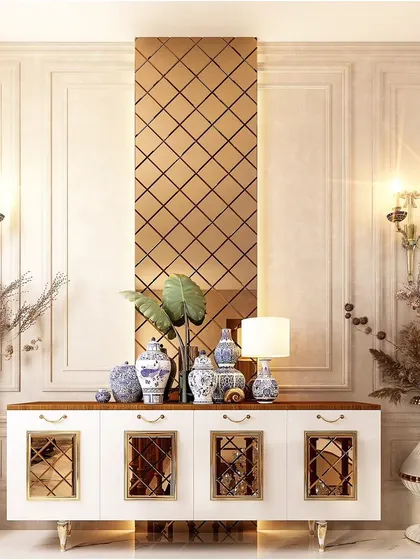 A classic and symmetrical foyer design. The white console table with mirrored doors is flanked by large decorative vases, set against a wall with traditional molding and a bronze-tinted mirror panel.