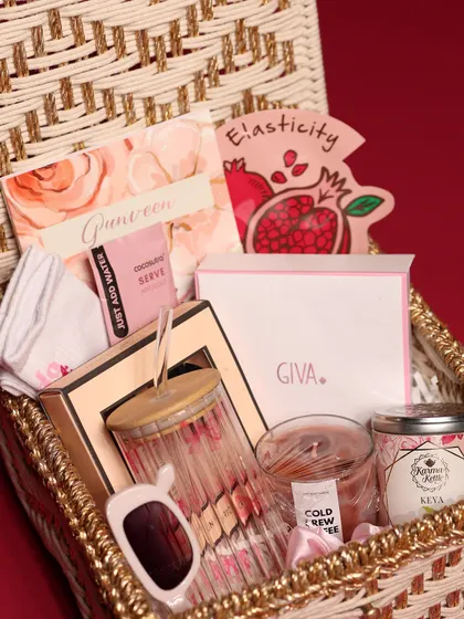 A close-up of the items inside the women's Christmas hamper, including a Giva jewelry box, a face mask, and a personalized card.