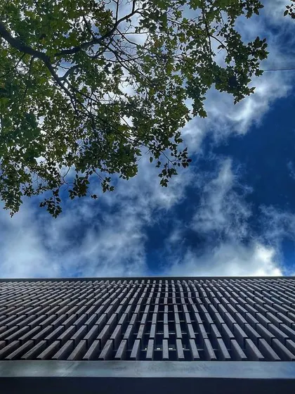 Looking up from the courtyard, the slatted roof frames the sky, reminding us of the world outside while maintaining a sense of enclosure.