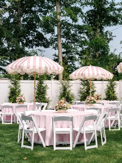 Elegant outdoor seating for the adults at the kids' party, with pink tablecloths and charming striped umbrellas.
