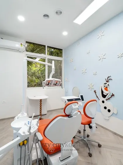 Natural light from the window complements the soft blue and white color scheme, making the treatment room feel open and airy. Every element, from the ergonomic chairs to the placement of equipment, is considered for both the patient's comfort and the dentist's workflow.