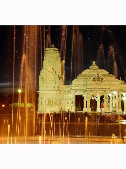 The temple viewed at night through a fountain. The illuminated architecture and the spray of water create a magical and serene scene, highlighting the beauty of the temple complex.