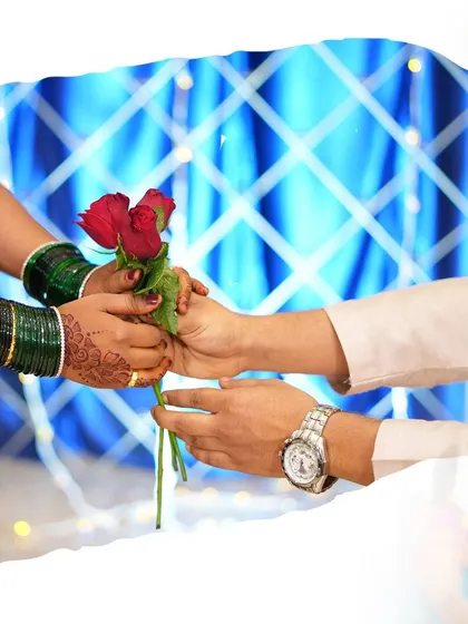 Detail shots are just as important as portraits. Here, I've focused on the couple's hands as they exchange a red rose, a classic symbol of love.
