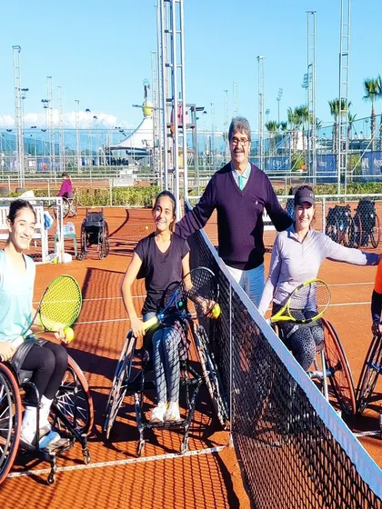 A group of our wheelchair tennis athletes and their coach posing on the court after a successful tournament. These shared experiences build lasting bonds and celebrate collective effort.