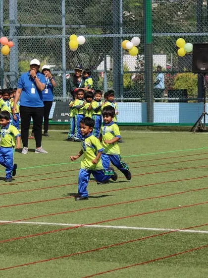 The thrill of the race. Young athletes from SNN School give it their all in a running event on our well-maintained turf, perfect for children's sports.