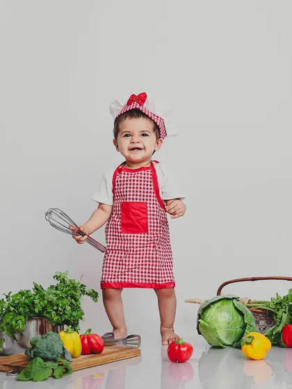 Let's get creative! This "Little Chef" themed photoshoot is a perfect example of how we build a whole world around your child's personality. We handle all the props, from the tiny apron to the fresh veggies.