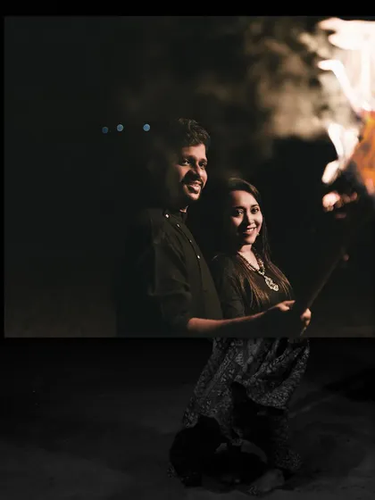 Sharing a warm moment by a bonfire at night. This is a great concept for a cozy and intimate pre-wedding session.