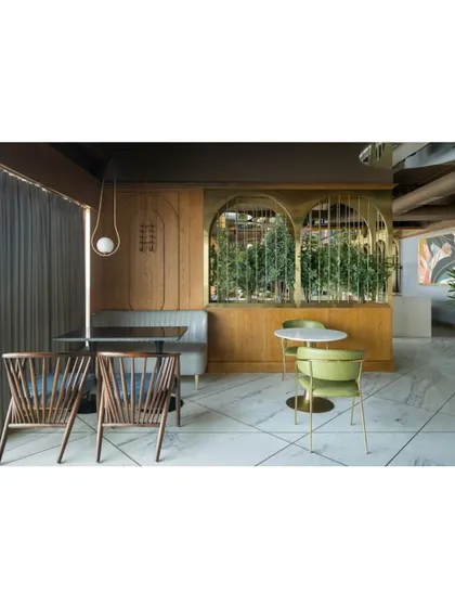 The dining area at Citadines is designed for fluid transitions, with a mix of seating types to accommodate everything from a quick coffee to a leisurely dinner. Slender brass arches frame planters, subtly defining zones without rigid separations.
