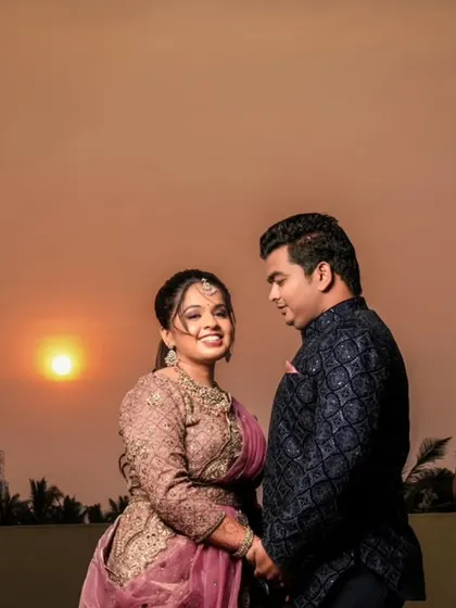 A happy, smiling portrait of the couple against the warm sunset.