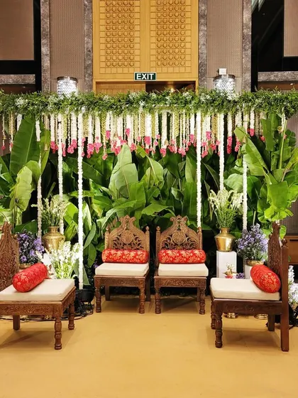 A seating arrangement for the couple's family during the ceremony, set against a backdrop of greenery and traditional decor.