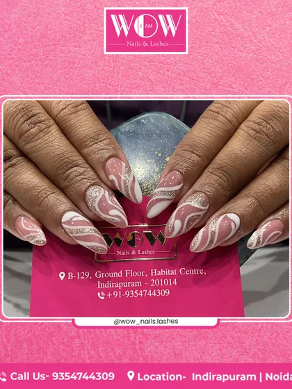 Abstract swirls of white and silver glitter on a neutral pink base give these almond-shaped extensions a dynamic and modern feel. This design is perfect for those who love unique, artistic nails.