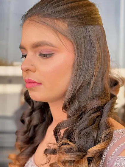 A soft and romantic party look with gentle curls and pink-toned makeup. Perfect for a daytime event or an engagement party.