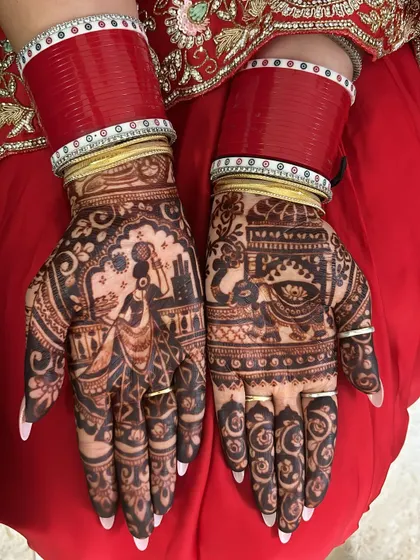 A traditional Karwa Chauth story on the palms. This design shows a woman carrying a pot on her head and a scene of a couple, capturing the essence of the festival.
