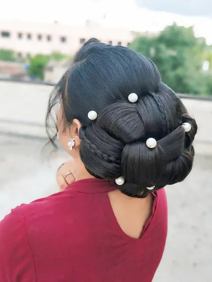 A complex braided and woven bun created by a student. This demonstrates their ability to combine multiple techniques into one cohesive, beautiful hairstyle.
