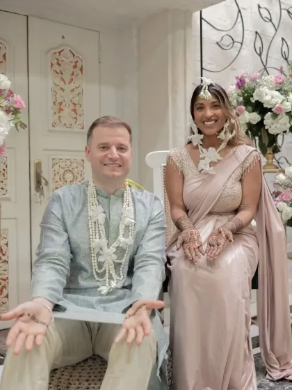 The bride and groom together, both with small henna designs, sharing a special moment.