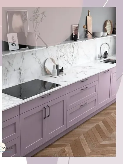 This kitchen features soft lilac-colored cabinets with a marble countertop and backsplash. The design incorporates a built-in induction stove and sleek black handles for a touch of modern contrast.