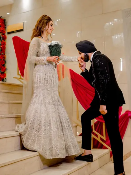 A chivalrous moment as the groom-to-be kisses his fiancée's hand on the staircase.