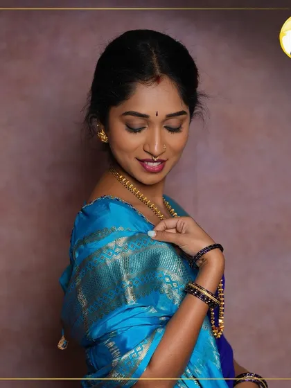 A classic South Indian look featuring a beautiful blue silk saree. The makeup is kept elegant with a soft brown smokey eye, a traditional bindi, and a berry-toned lip to complement the rich fabric.