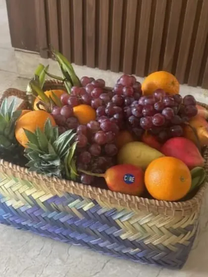 A simple yet elegant option for gifting is a handwoven basket filled with fresh, seasonal fruits. This colorful arrangement of grapes, oranges, and pineapples is both healthy and beautiful.
