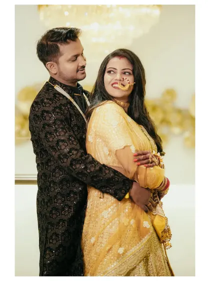 A sweet, candid moment between the couple. The bride's playful glance over her shoulder and the groom's gentle embrace make for a charming photo.