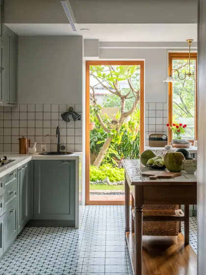 The kitchen is the heart of a home, and this one in Calcutta opens directly onto a lush garden. We used soft, muted green cabinetry and classic checkered tiles to create a timeless feel. It’s a bright, welcoming space where the simple joys of cooking are connected to the beauty of the outdoors.
